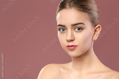 Beautiful young woman with laminated eyelashes on color background