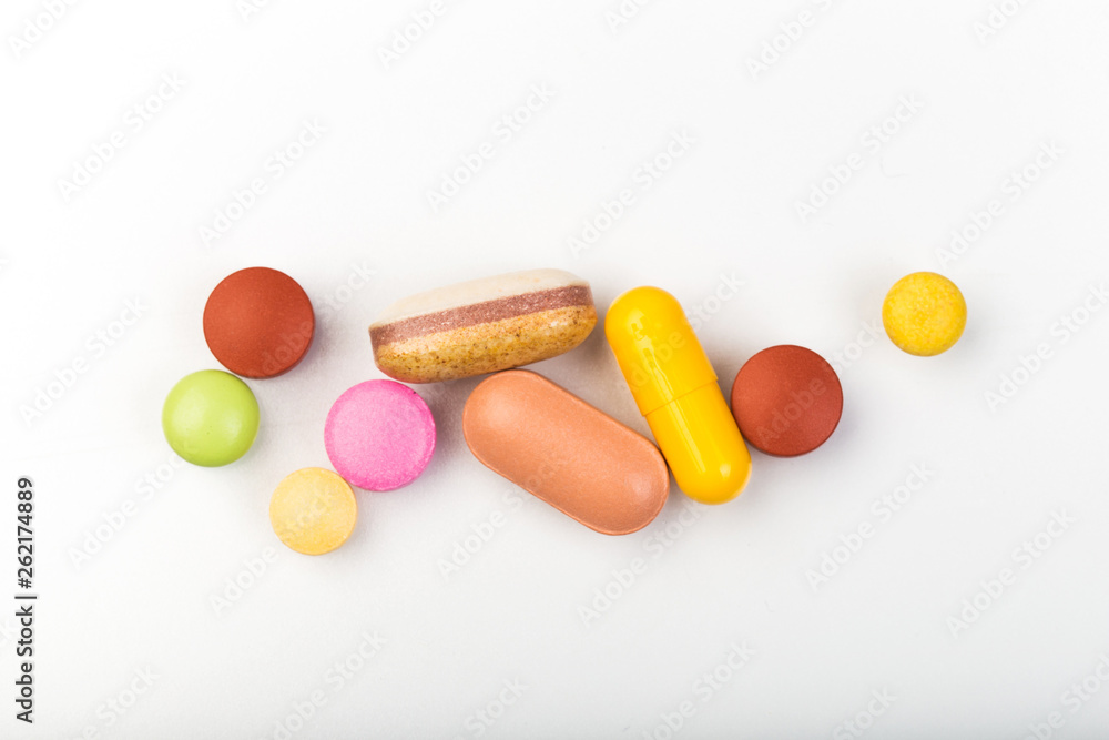 set of multi-colored tablets and capsules on a white background set of multi-colored tablets and capsules on a white background