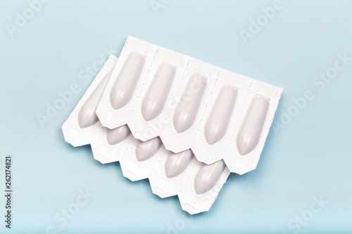 plastic packs of suppositories on blue  background