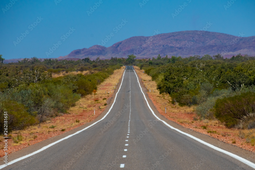 Empty hot road in Western Australia leading towards Karijini National Park