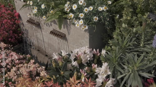 Garden water feature surrounded by flowers and bedding plants. photo