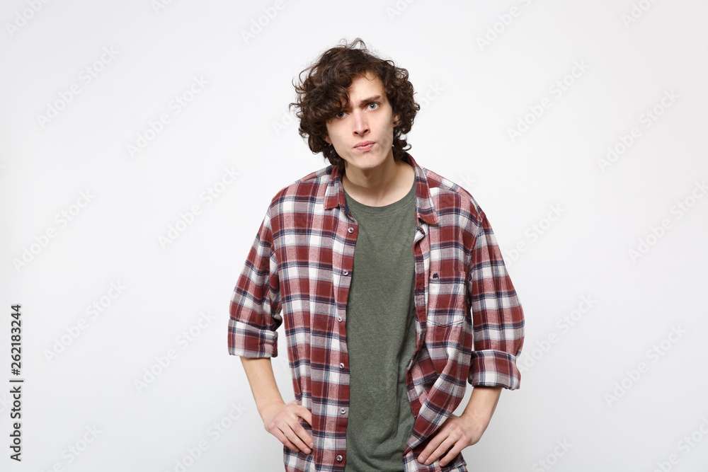 Portrait of perplexed strict young man in casual clothes standing with arms akimbo on waist isolated on white wall background in studio. People sincere emotions, lifestyle concept. Mock up copy space. Portrait of perplexed strict young man in casual clothes standing with arms akimbo on waist isolated on white wall background in studio. People sincere emotions, lifestyle concept. Mock up copy space.