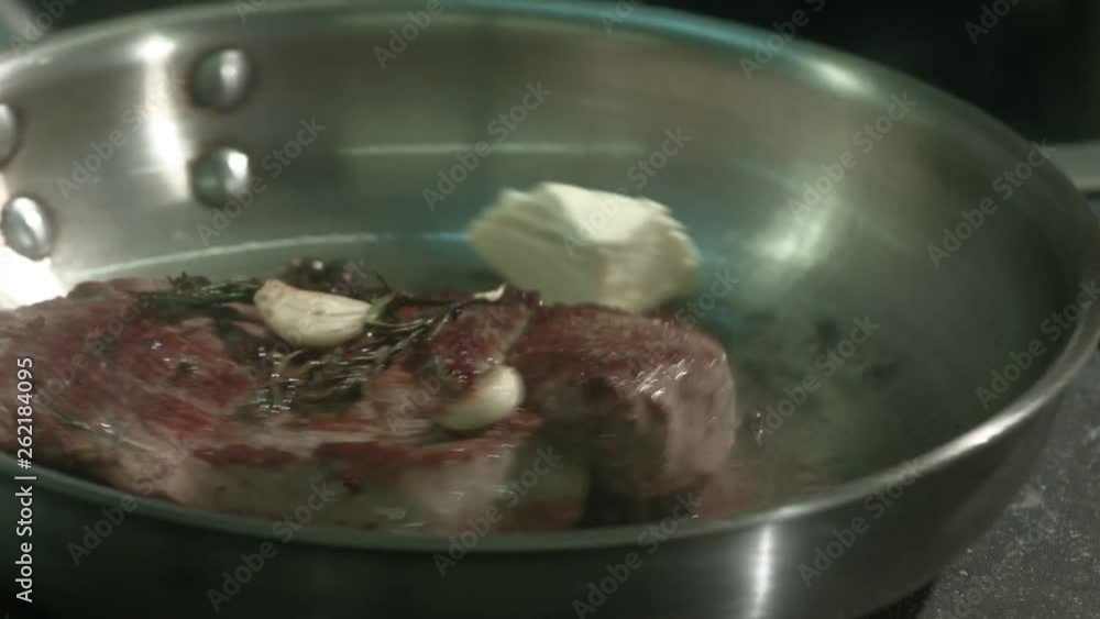 Beef steak with rosemary frying on a pan in a professional restaurant kitchen Beef steak with rosemary frying on a pan in a professional restaurant kitchen