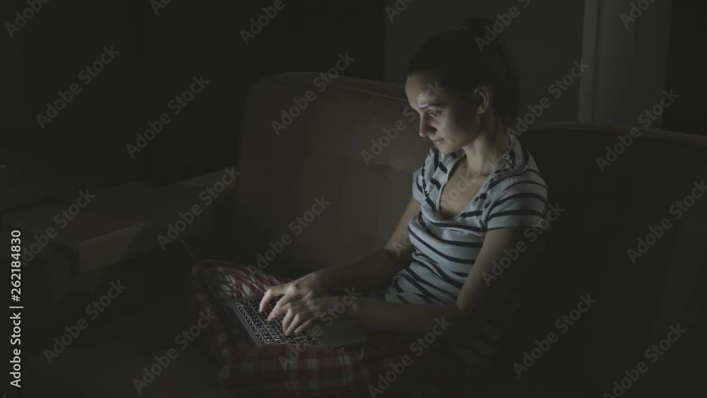 European brunette woman communicates on the Internet through a computer in the evening European brunette woman communicates on the Internet through a computer in the evening