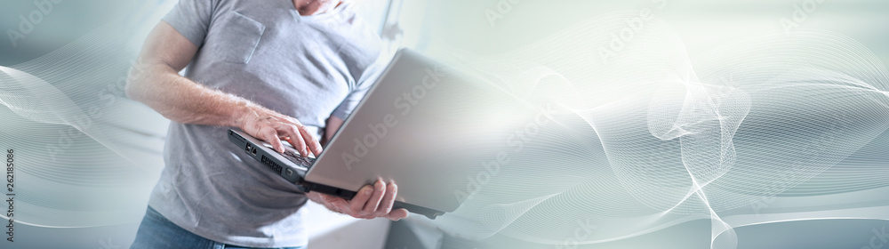 Businessman standing and working on his laptop. panoramic banner Businessman standing and working on his laptop. panoramic banner