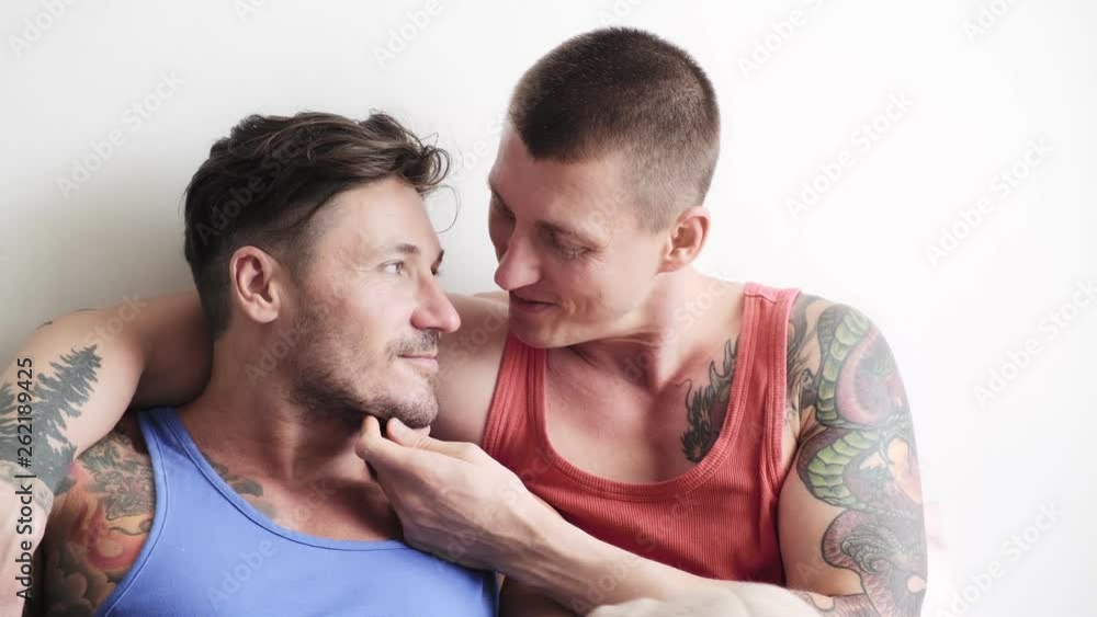 Young gay male couple in bed together, intimate. Sweet talk, pillow talk. Happy gay friendship, relationship, pride concept. Young gay male couple in bed together, intimate. Sweet talk, pillow talk. Happy gay friendship, relationship, pride concept.