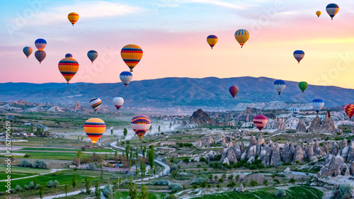 Colorful hot air balloons flying over rock landscape at Cappadocia Turkey photo