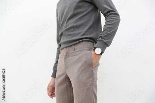 close-up of A handsome man in gray turtleneck shirt and long trousers on white background.