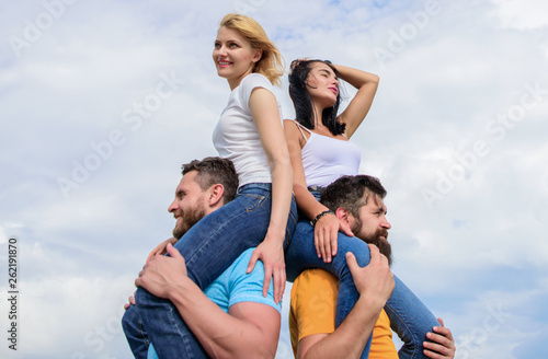 Summer vacation and fun. Couples on double date. Inviting another couple to join. Twice fun on double date. Friendship of families. Couples in love having fun. Men carry girlfriends on shoulders