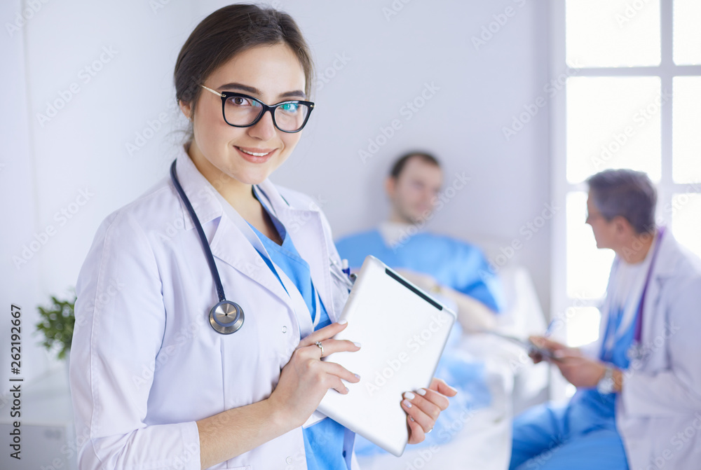 Female doctor using tablet computer in hospital lobby Female doctor using tablet computer in hospital lobby