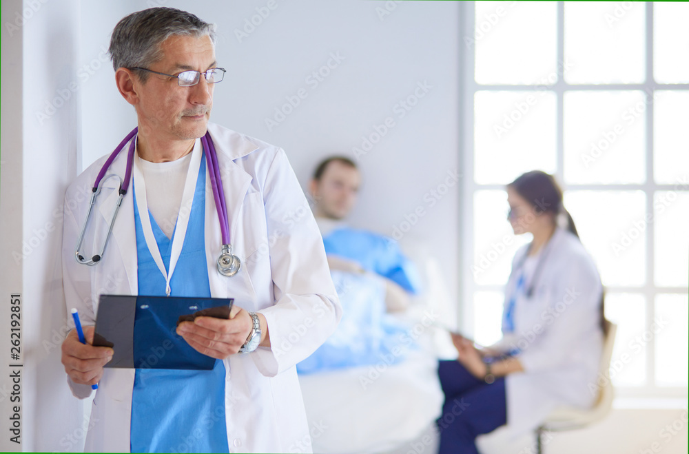 Doctor holding folder in front of a patient and a doctor Doctor holding folder in front of a patient and a doctor