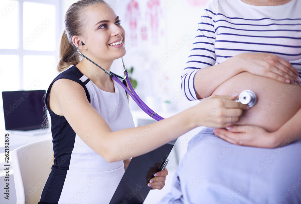 Young female doctor examining pregnant woman at the clinic.