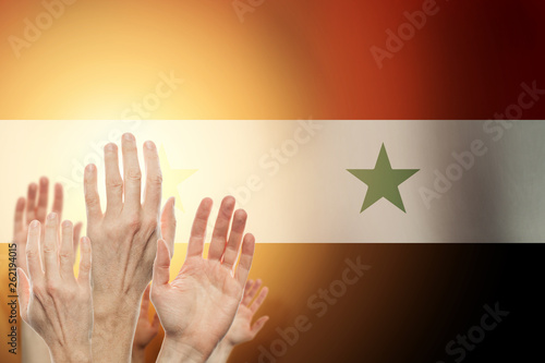 People raising hands and flag Syria on background. Patriotic concept photo