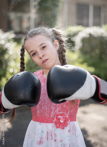 Mädchen mit Zöpfen trägt Boxhandschuhe, Porträt photo