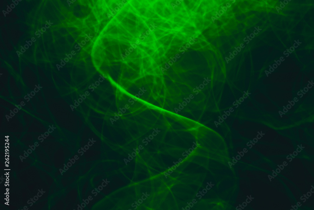 Green neon intertwined smoke. Abstract black background. Neon lights texture.