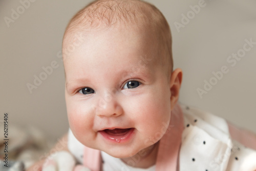 Portrait of cute cheerful baby girl in her room