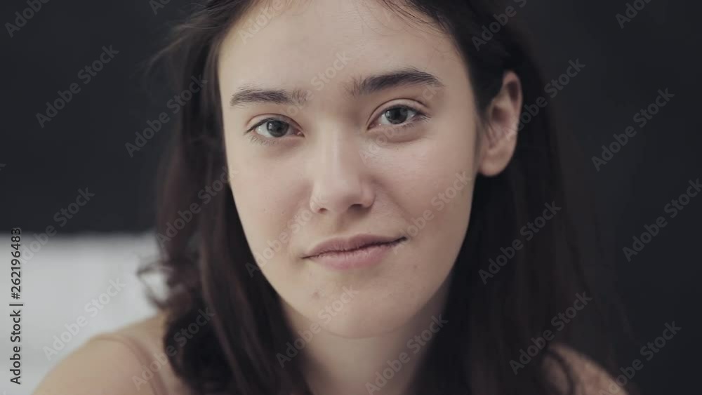 Portrait of a young lesbian woman sitting on the bed and looking at camera. Portrait of a young lesbian woman sitting on the bed and looking at camera.