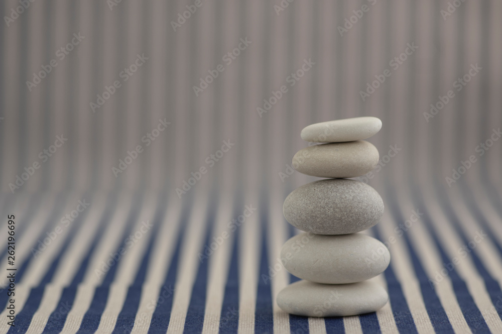 Harmony and balance, pebble rock cairn, simple poise stones on white and blue striped background, rock zen sculpture, one tower Harmony and balance, pebble rock cairn, simple poise stones on white and blue striped background, rock zen sculpture, one tower