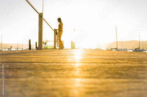 young teen on a jetty at sunset