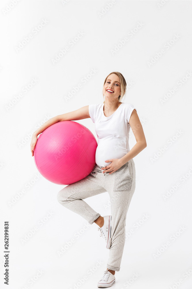 Beautiful young pregnant yoga fitness woman posing isolated over white wall background make exercises with ball. Beautiful young pregnant yoga fitness woman posing isolated over white wall background make exercises with ball.