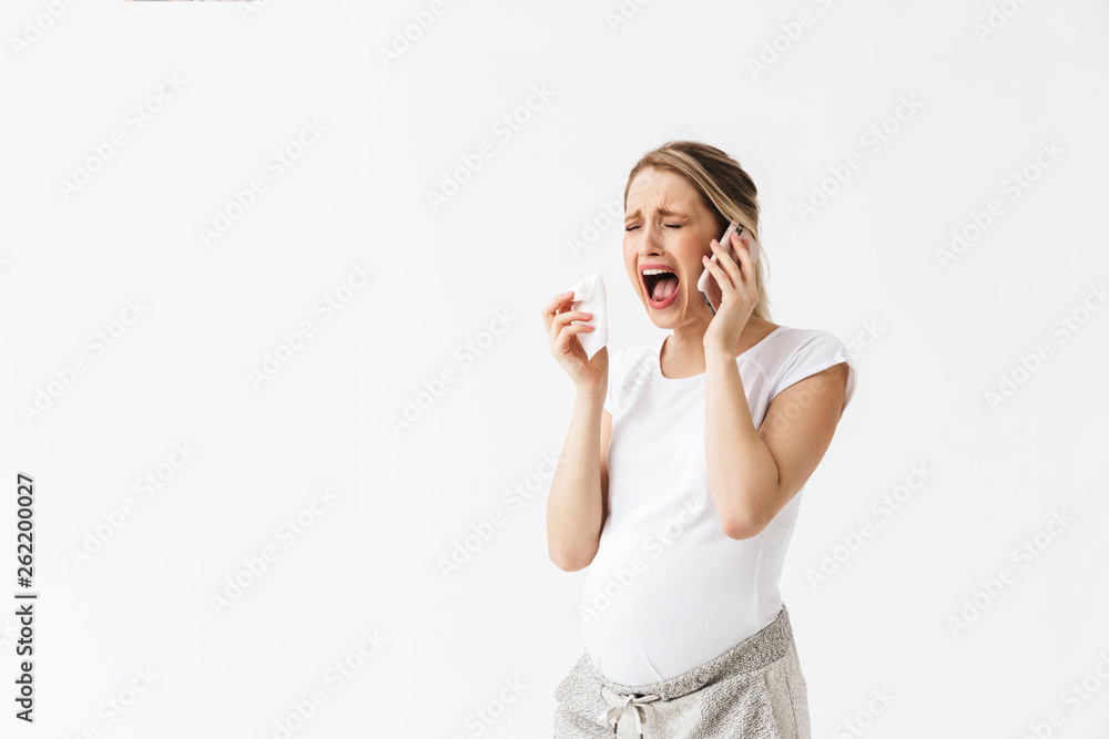 Sad young pregnant woman posing isolated over white wall background holding napkin cry. Sad young pregnant woman posing isolated over white wall background holding napkin cry.