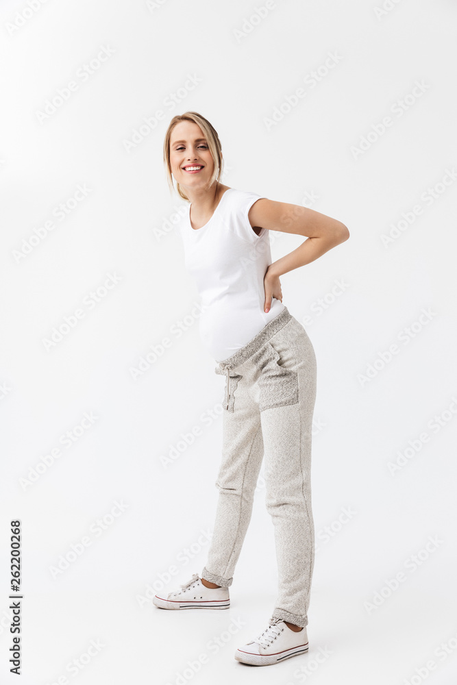 Beautiful young pregnant woman posing isolated over white wall background. Beautiful young pregnant woman posing isolated over white wall background.