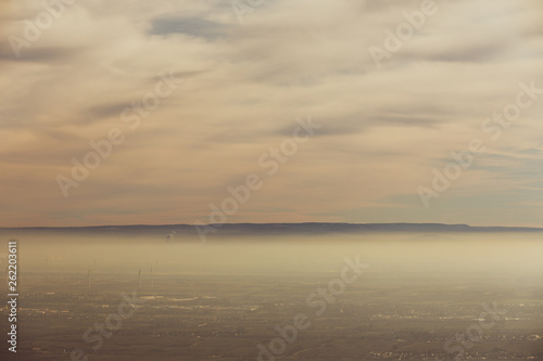 Landschaft Rheinebene mit Windr  dern unter einer Nebeldecke und Wolkendecke