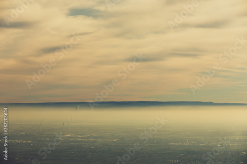 Landschaft Rheinebene mit Windr  dern unter einer Nebeldecke und Wolkendecke