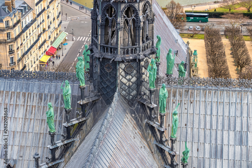 Detail of The spire of Notre Dame Cathedral with Archangel Gabriel in the foreground. Behind, around the spire, the bronze figures of the apostles and the evangelists.