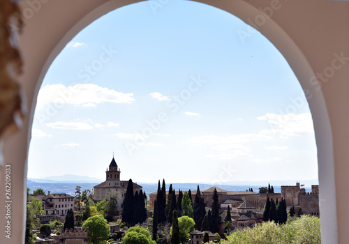 View of the bell tower of the Alhambra through the arched window from the Generalife gardens in Granada, Spain
