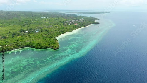 Aerial: Flying over tropical beach turquoise water coral reef , Tomia island Wakatobi National Park Indonesia Maldives Polynesia white sand beach photo