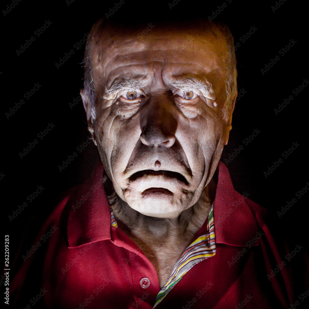 Portrait of old and sad caucasian man. Low-key lighting. Isolated on black. Portrait of old and sad caucasian man. Low-key lighting. Isolated on black.