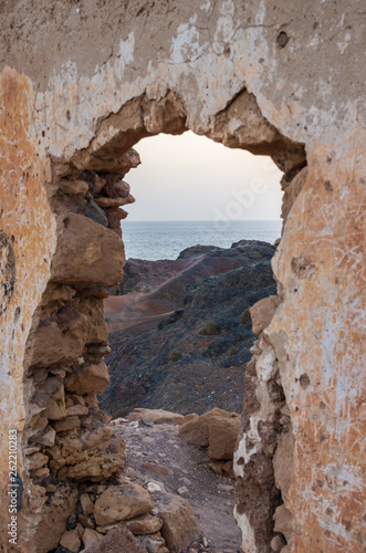 Wall with gate of a building demolished on a cliff facing the sea © GaiBru Photo