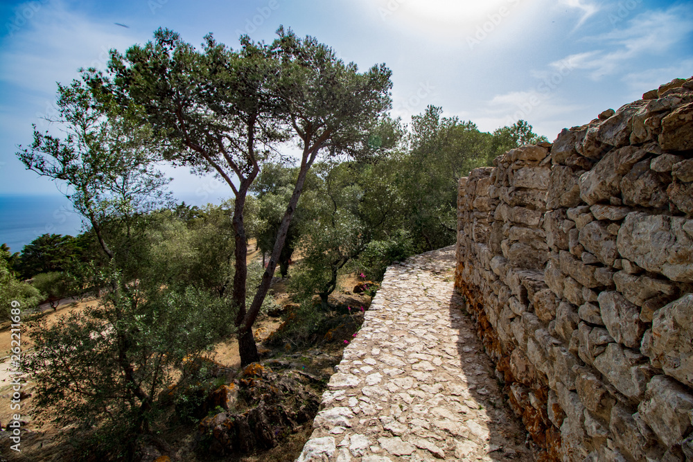 blue sea in the background with part of the castle wall in the foreground