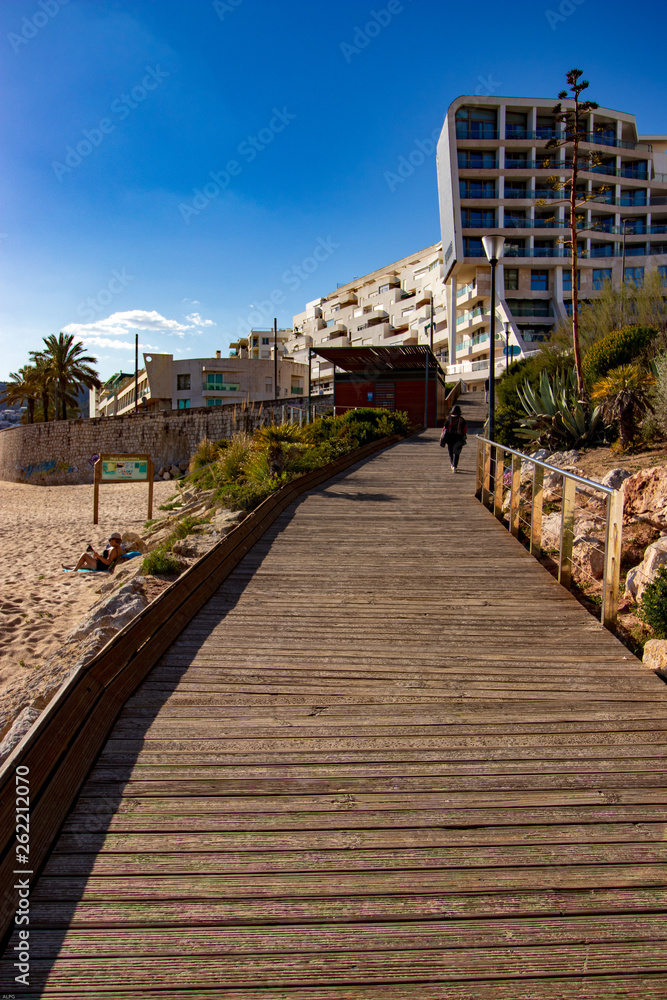 wooden walkway on the beach with blue sky in the background