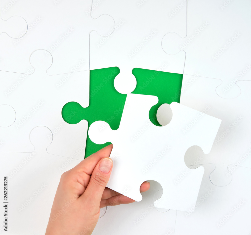 female hand puts white big puzzles female hand puts white big puzzles