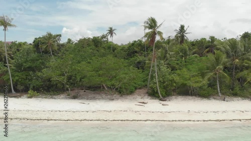 Aerial: Flying over tropical beach turquoise water coral reef , Tomia island Wakatobi National Park Indonesia Maldives Polynesia white sand beach. Native cinelike D-log color profile photo