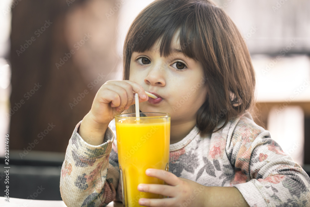 Little girl in a cafe drinking juice Little girl in a cafe drinking juice
