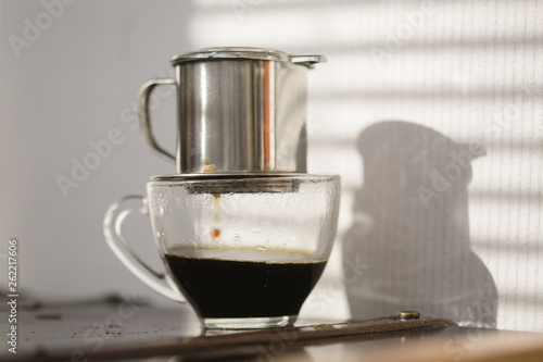 Coffee brewing on sunset. Traditional Vietnamese phin filtered coffee minimalist style.