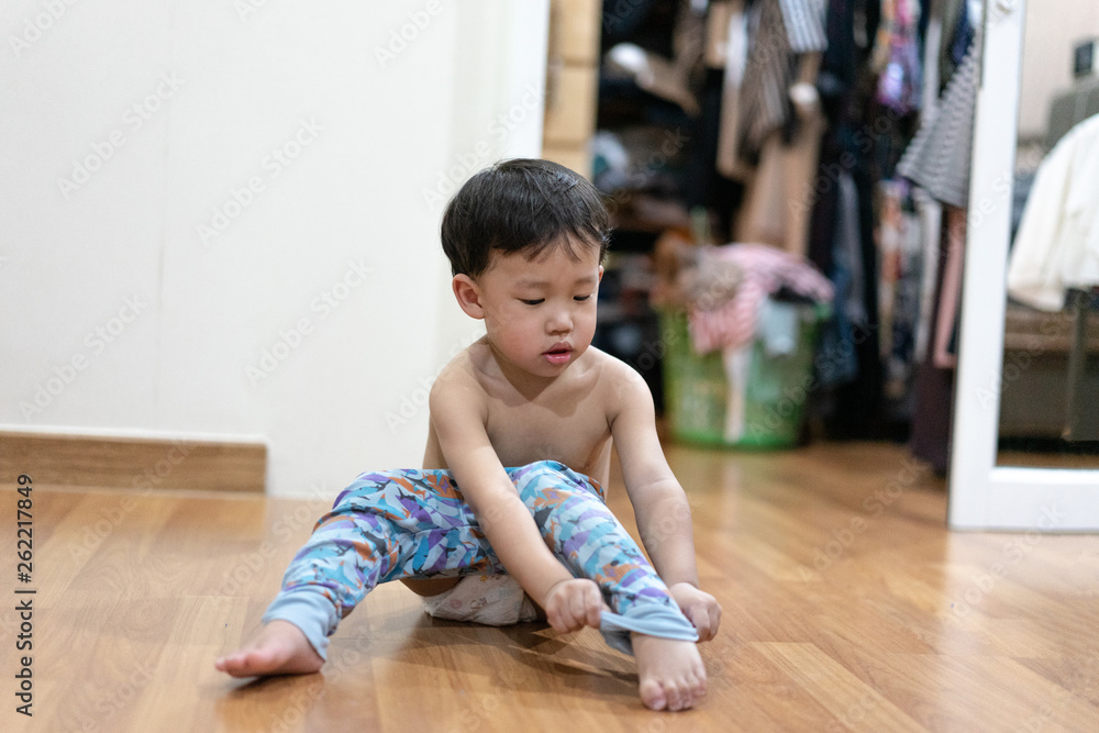 The boy tried to wear pajamas by himself. The boy tried to wear pajamas by himself.