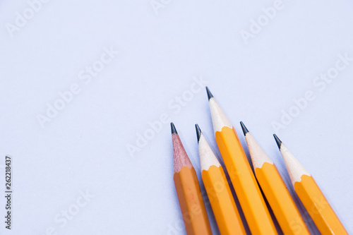 five simple pencils on a lilac background with a copy space. selective focus