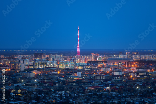 Aerial view of Yakutsk, Yakutia skyline with TV tower illuminated in bright colors and center of city in beautiful post sunset twilight during blue hour photo