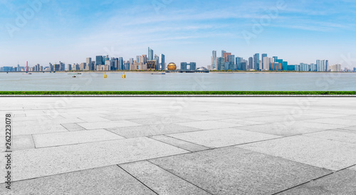 Empty square tiles and skyline of urban buildings..