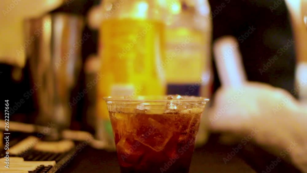 Closeup shot building cocktail in a plastic cup Closeup shot building cocktail in a plastic cup