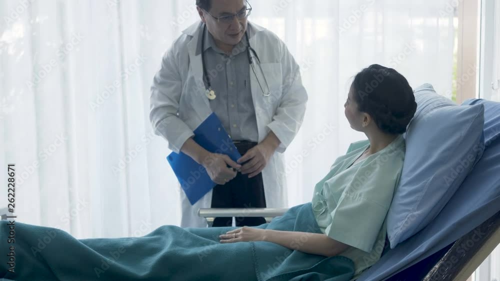 The senior male doctor talked and inquired about the patient's illness at the patient's bed. The senior male doctor talked and inquired about the patient's illness at the patient's bed.