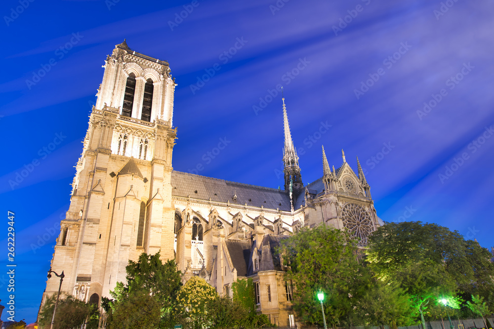 Notre Dame Cathedral facade against a beautiful blue sky at night, Paris - France