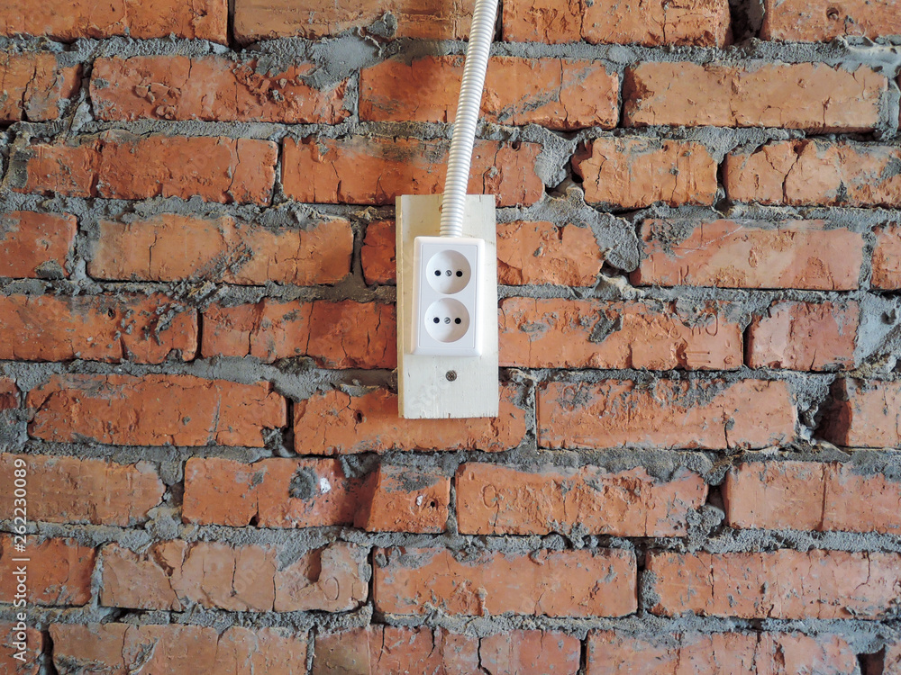red brick wall with white electrical plug socket red brick wall with white electrical plug socket