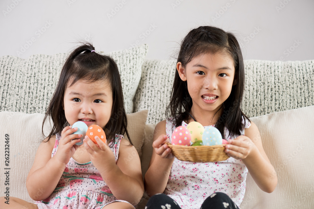 Happy easter! Two cute little children sitting on sofa with Easter eggs in the nest or basket. Happy easter! Two cute little children sitting on sofa with Easter eggs in the nest or basket.