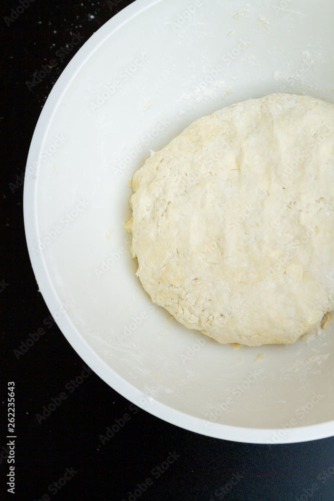 Raw mixed dough lies in a mixing bowl Raw mixed dough lies in a mixing bowl
