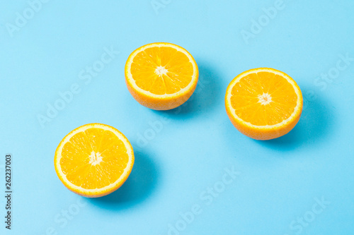 Half cut orange on a blue background. Concept of tropical fruits  vacation and travel  diet and weight loss.